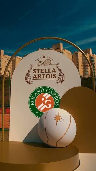 Ativação da Stella Artois em Roland Garros, com bola dourada sobre pódio e totem da marca